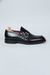 Black leather loafers with silver buckle detail, ideal for formal business wear.